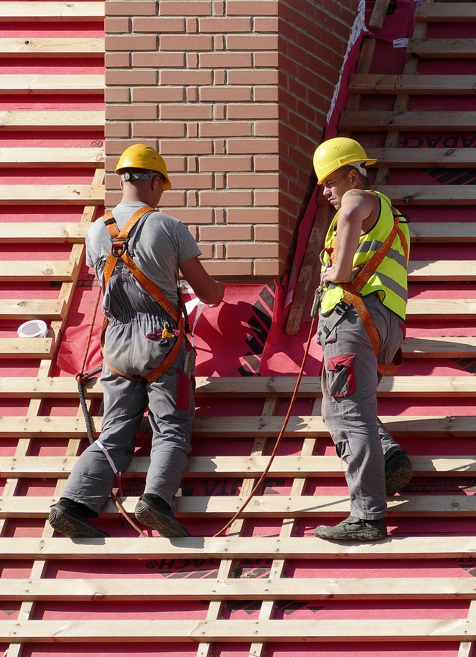 2 roofers working on a project in victorville, california a metal roofing project